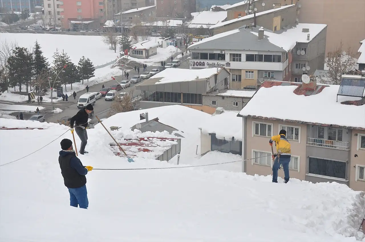 Muş'ta işçiler bellerine bağladıkları iplerle çatılarda kar temizliyor