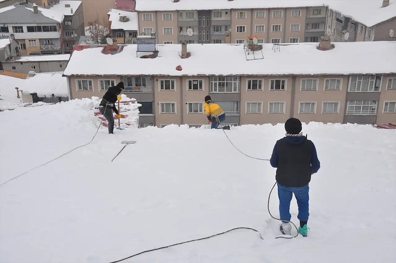 Muş'ta işçiler bellerine bağladıkları iplerle çatılarda kar temizliyor