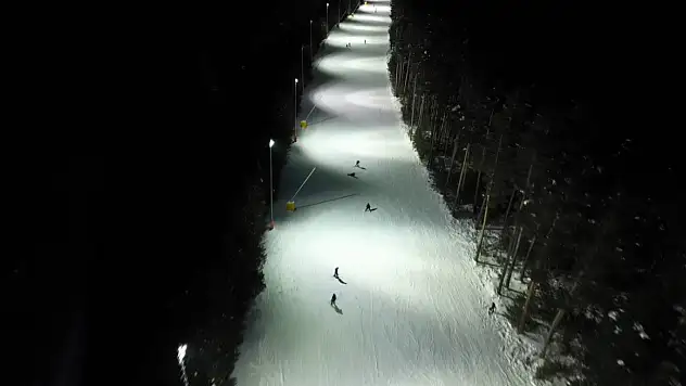 Kristal kar gece ışıklarında parlıyor