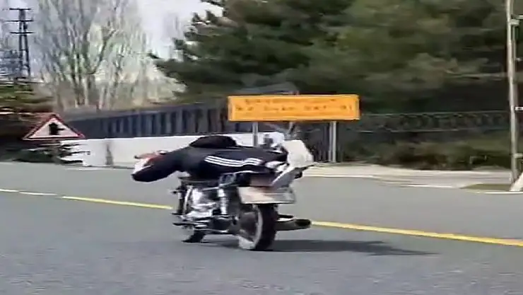 Motosikletin üzerine uzanarak etrafa baktı