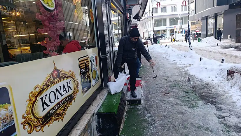 Ağrı'da bir esnaf, buzda müşterilerinin düşmemesi için harekete geçti